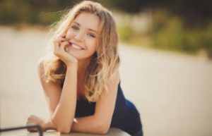 young smiling blonde in a black dress